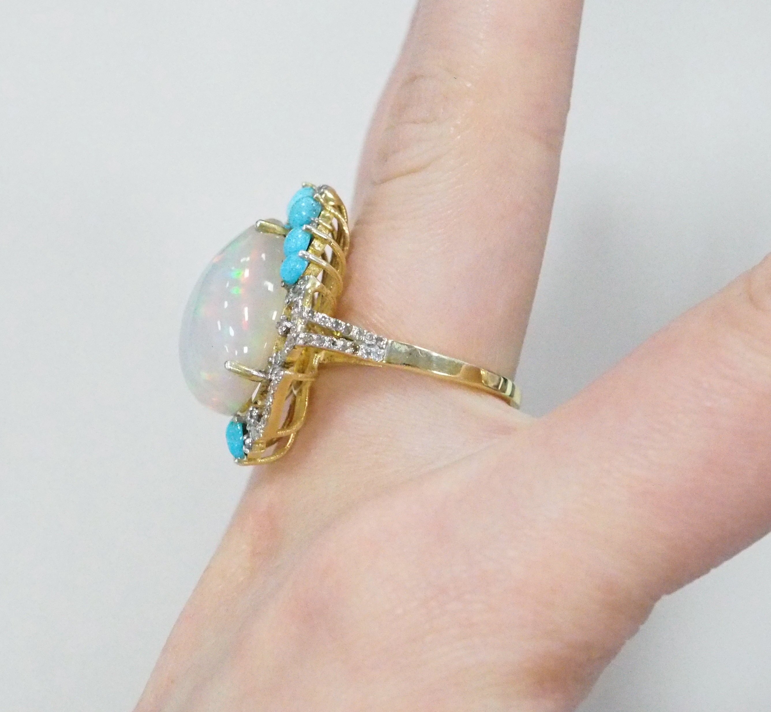 Серебряное кольцо 925 пробы; вставки 1 Опал бел. 12,86ct (Эфиопия); 8 Бирюза 1,24ct; 88 Бр.Кр-17 0,6ct 4/4;